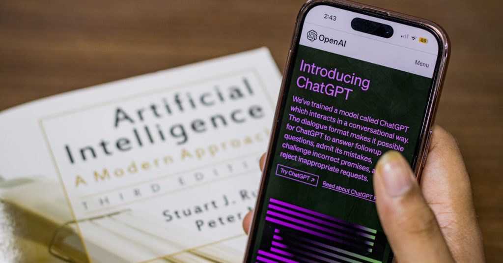 Close-up of a smartphone displaying ChatGPT app held over AI textbook.