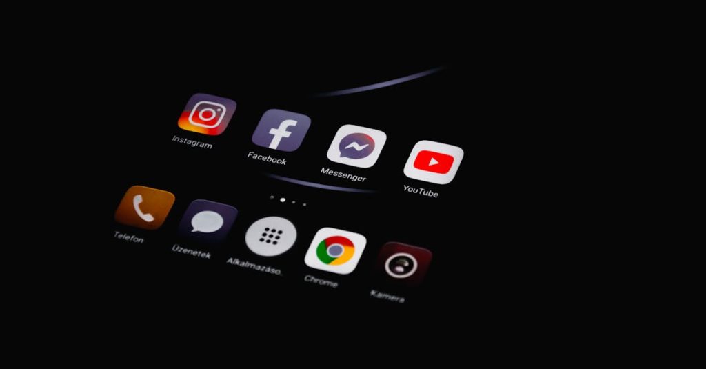 Close-up of smartphone displaying popular social media apps in dim lighting.